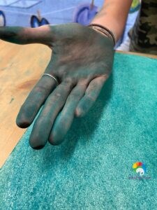 A hand filled with green paint